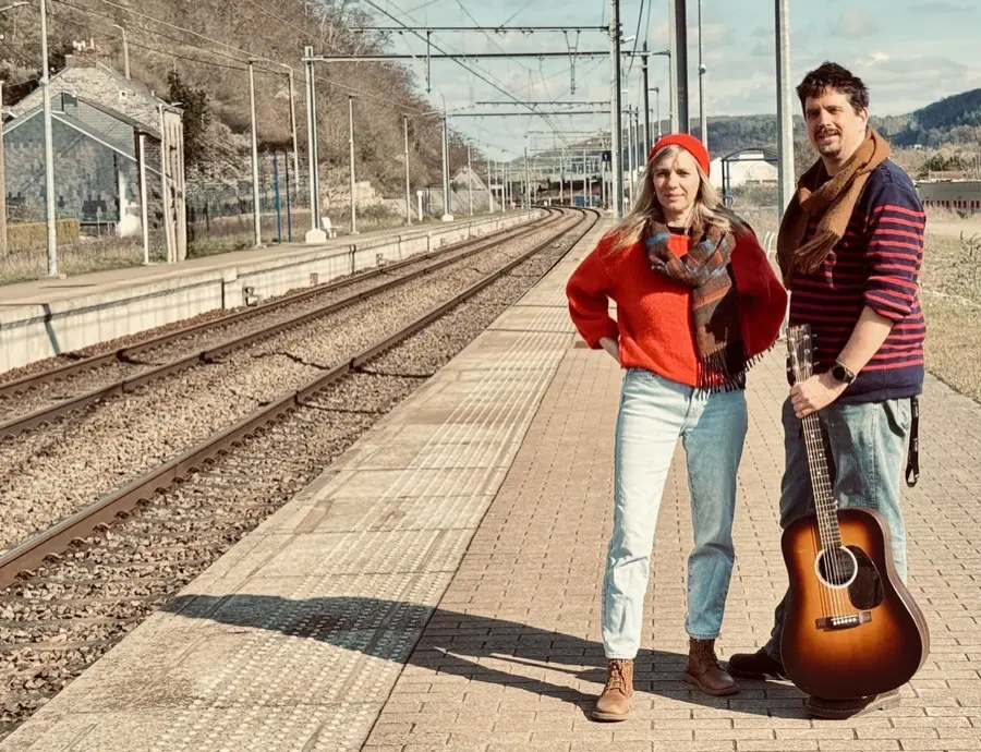 Cath et François sous un pont, guitare à la main